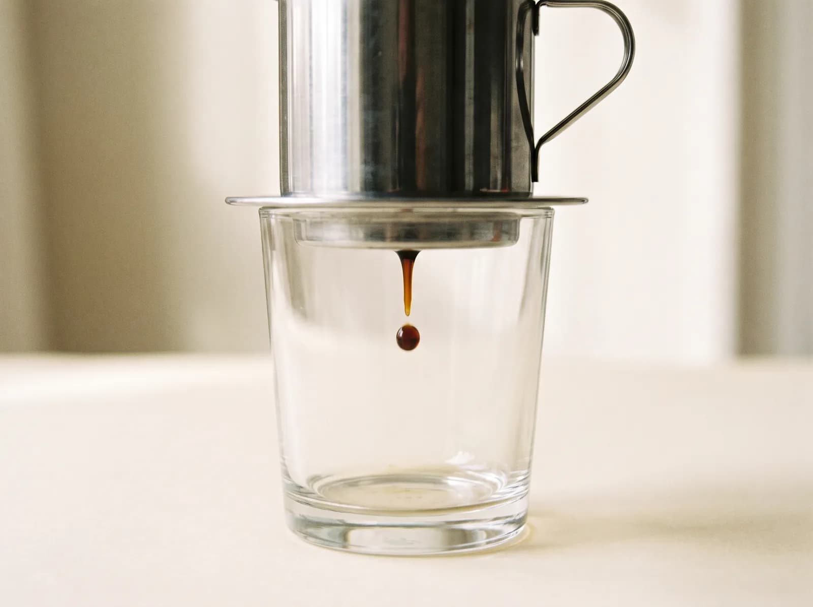 A phin filter dripping into a glass